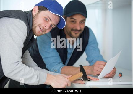 two men fitting a new kitchen Stock Photo