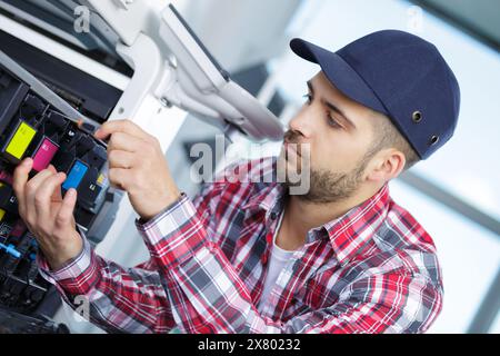 man fixing cartridge in photocopy machine at office Stock Photo