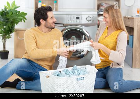 happy couple having fun doing laundry together Stock Photo