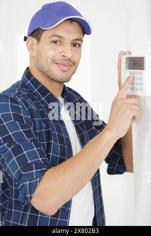 male electrician installing security system door Stock Photo