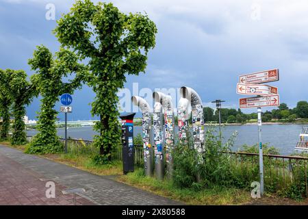 ventilation pipes on the banks of the Rhine covered with many stickers, pollard linden trees, Cologne, Germany. mit vielen Aufklebern beklebte Lueftun Stock Photo