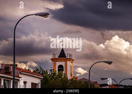 Ruidera's bell tower with street lamps at sunset. Stock Photo