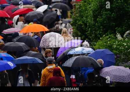 Members of the public shelter under umbrellas the RHS Chelsea Flower Show at the Royal Hospital Chelsea in London. Heavy rain could bring flooding and travel disruption across much of the UK on Wednesday and Thursday with an amber warning issued for part of the country. Picture date: Wednesday May 22, 2024. Stock Photo