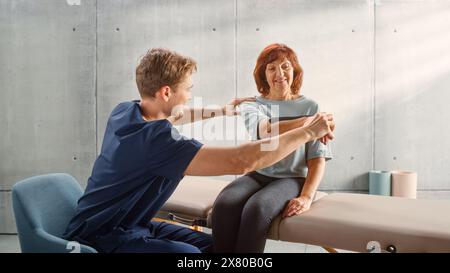 Professional Sport Physiotherapy Specialist Stretching and Working on Specific Muscles, Shoulder Joints with Elderly Woman. MIddle Aged Female Recovering from Mild Injury, Undergoing Rehabilitation. Stock Photo