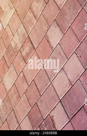 An upclose shot of a diagonal patterned red brick floor, resembling brown brickwork. The rectangular shapes create a unique flooring design Stock Photo