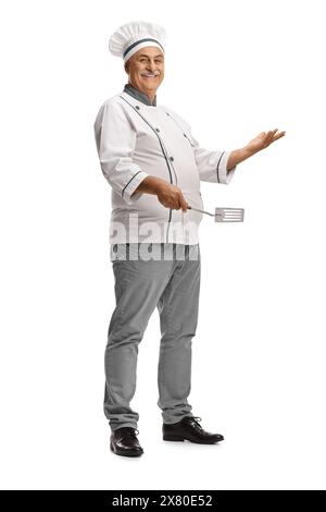 Mature male chef holding a turner utensil isolated on white background Stock Photo