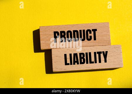 Product liability words written on wooden blocks with yellow background. Conceptual product liability symbol. Copy space. Stock Photo