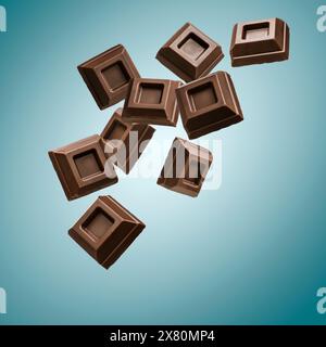 Dark chocolate blocks flying on blue background. Stock Photo