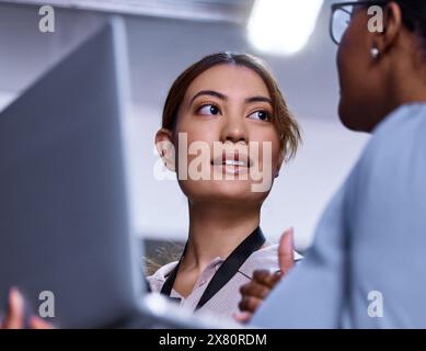 Women, laptop and communication in server room for IT, cybersecurity and collaboration in workplace. Female programmers, computer and discussion with Stock Photo