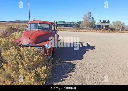 Old car and earthship building with greenhouse and solar panels, part of the Greater World Earthship Community, near Taos, New Mexico Stock Photo