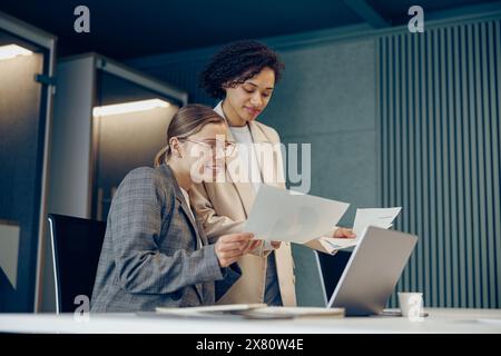 Two female professional executives experts discussing financial accounting papers working together Stock Photo
