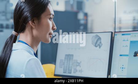 Portrait of an Asian Industrial Engineer Developing Hydraulic Model of a Heavy Industry Machine Part on Computer CAD Software in a Factory. Modern Technological Research and Development Center. Stock Photo