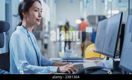 Portrait of an Asian Industrial Engineer Developing Models of a Heavy Industry Machine Parts on Computer CAD Software in a Factory. Modern Technological Research and Development Center. Stock Photo
