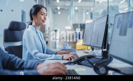 Factory Office Room: Industrial Engineers Developing Models of a Heavy Industry Machine Parts on a Computer 3D Software. Modern Technological Industry 4.0 Research and Development Center. Stock Photo