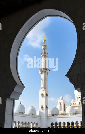 A serene view of the iconic minaret through an archway at Sheikh Zayed Grand Mosque, Abu Dhabi. Stock Photo