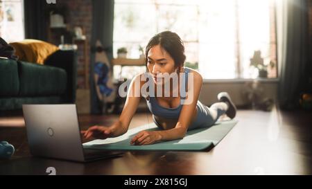 Girl Workout, Watching Trainer on Laptop, via Online Video Tutorial while Training at Home. Athletic Woman Using Technology, Streaming Service Fitness Subscription for Virtual Training Stock Photo