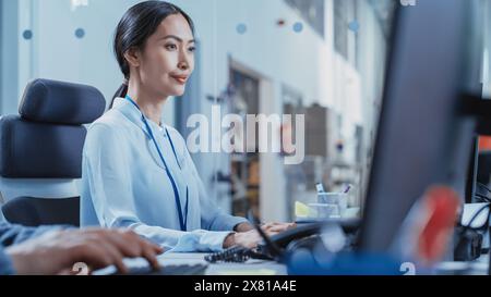 Portrait of an Asian Industrial Engineer Developing Models of a Heavy Industry Machine Parts on Computer CAD Software in a Factory. Modern Technological Research and Development Center. Stock Photo