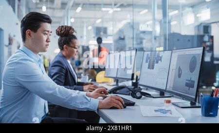 Factory Office Room: Industrial Engineers Developing Models of a Heavy Industry Machine Parts on a Computer 3D Software. Modern Technological Industry 4.0 Research and Development Center. Stock Photo