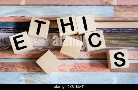 Ethics word written in a wooden cube on a vintage background Stock Photo