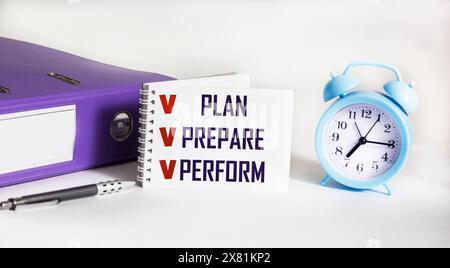 plan, cook, execute words written on a notepad with checked checkboxes on a white background with a clock and a folder Stock Photo