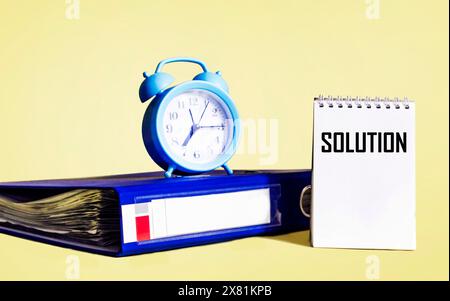 The word solution written on a notepad on a yellow background Stock Photo