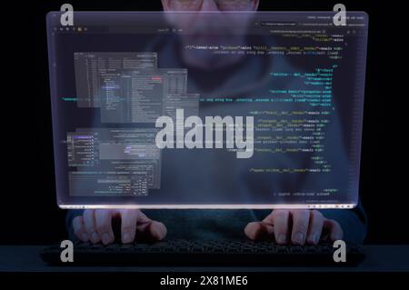 Close-up of a man's hands on a keyboard and a virtual screen with the windows of a software development system. Concept of software development, codin Stock Photo