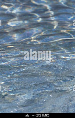 Clear water in the rays of the sun. Water background. Ripples on the surface of the water. Stock Photo