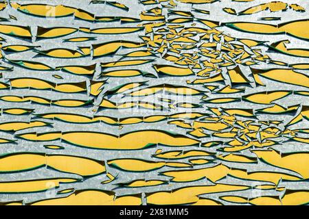Cracked paint. Unusual beautiful yellow-gray background. Peeling of paint from the surface, close-up. Stock Photo
