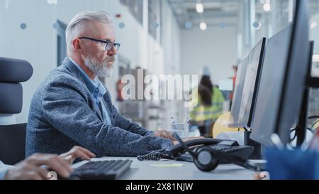 Factory Office Room: Industrial Engineer Working on Development Model of a Heavy Industry Machine Part on a Computer 3D Software. Modern Technological Industry 4.0 Research and Development Center. Stock Photo