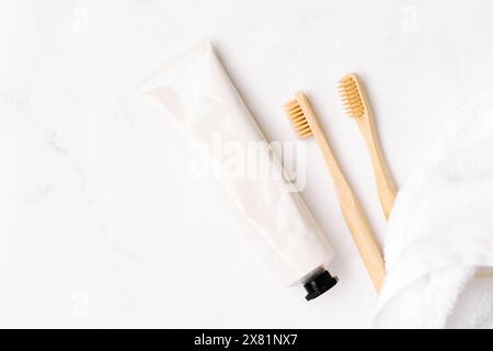 Top view of white metal tube without label and toothbrushes on white background. Mockup scene for cosmetic, toothcare Copy space. Flat lay Stock Photo
