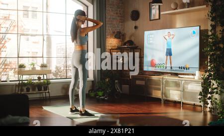 Active Girl Workout, Watching Personal Trainer through Online Video Tutorial while Training at Home. Athletic Fit Woman Using Technology, Streaming Service Fitness Subscription for Virtual Training Stock Photo