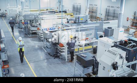 Industrial Factory: Diverse Team of Engineers, Technicians, Professionals and Workers, Working on Production Plant, Optimizing CNC Machinery, Programming Machines, Executing Orders.Top View. Stock Photo