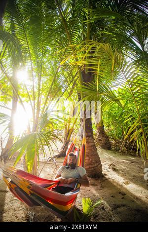 man working on laptop on exotic beach Stock Photo
