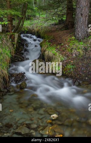 Small creek on slope between Brig town and Simplonpass in spring sunny morning Stock Photo