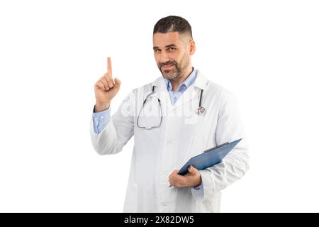 Confident Man Doctor Pointing Up While Holding Clipboard Stock Photo