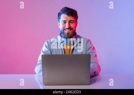 Man Sitting at Table Using Laptop Computer Stock Photo