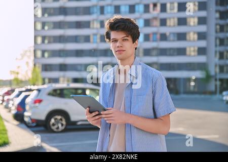 Young handsome male using digital tablet on city street Stock Photo