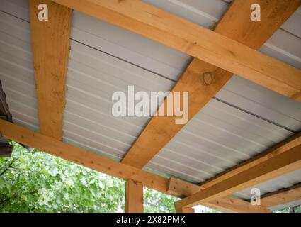 Close-up of wooden roof rafters with metal corrugated board, bottom view Stock Photo