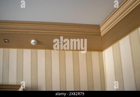 Part of the living room, corner of the wall from the ceiling, mounted LED lights in a wooden console on the ceiling Stock Photo