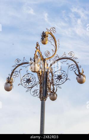 lantern hanging against the clear sky, illuminating with ornate metal design Stock Photo
