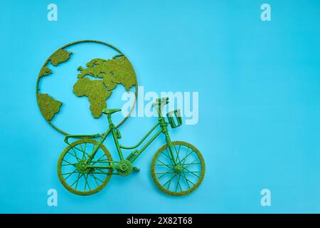 World Bicycle Day. Green Bicycle with World Map Art on Blue Background Stock Photo