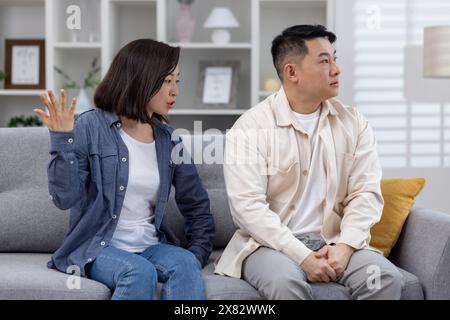 Man and woman having a serious discussion at home, portraying conflict and relationship issues. Stock Photo