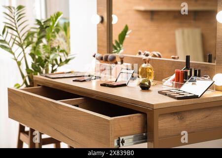 Makeup products on table in dressing room, closeup Stock Photo