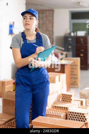 Female foreman making task list in building under construction Stock Photo