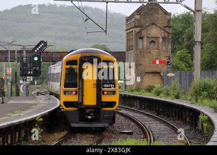 Northern trains express sprinter train, number 158791, leaving Carnforth railway station platform 2 on 22 May 2024 and passing a feather signal. Stock Photo