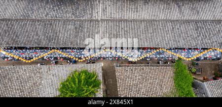 NINGBO, CHINA - MAY 19, 2024 - Tourists taste food at the long table banquet in Qiantong Ancient Town in Ningbo, Zhejiang province, China, May 19, 202 Stock Photo