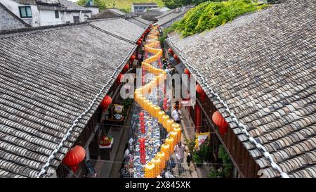 NINGBO, CHINA - MAY 19, 2024 - Tourists taste food at the long table banquet in Qiantong Ancient Town in Ningbo, Zhejiang province, China, May 19, 202 Stock Photo