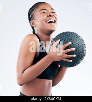 Black woman, laugh and happy with slam ball in studio on white background for fitness or exercise and health. Female person, smile and confident with Stock Photo