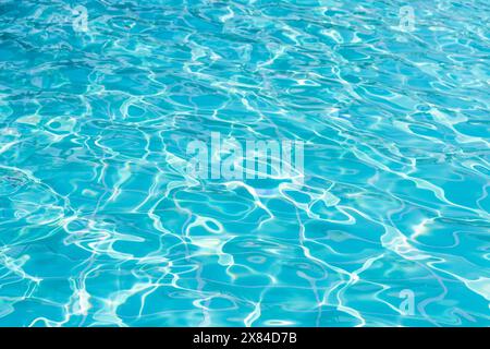 Blue swimming pool water surface and ripple wave background. Summer abstract reflection caustics in swimming pool. Stock Photo