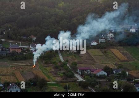 agricultural waste bonfires from dry grass and straw stubble burning with thick smoke polluting air during dry season causing global warming and carci Stock Photo